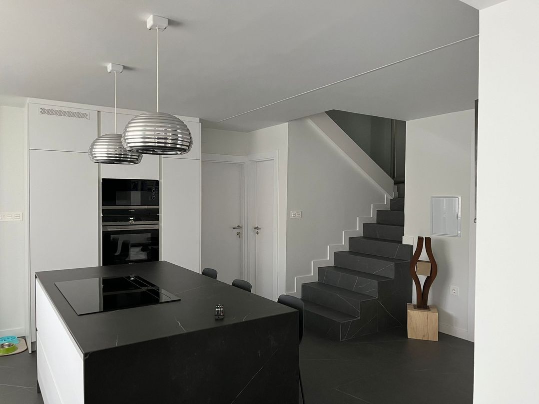 escaleras de acceso desde cocina blanca y negra